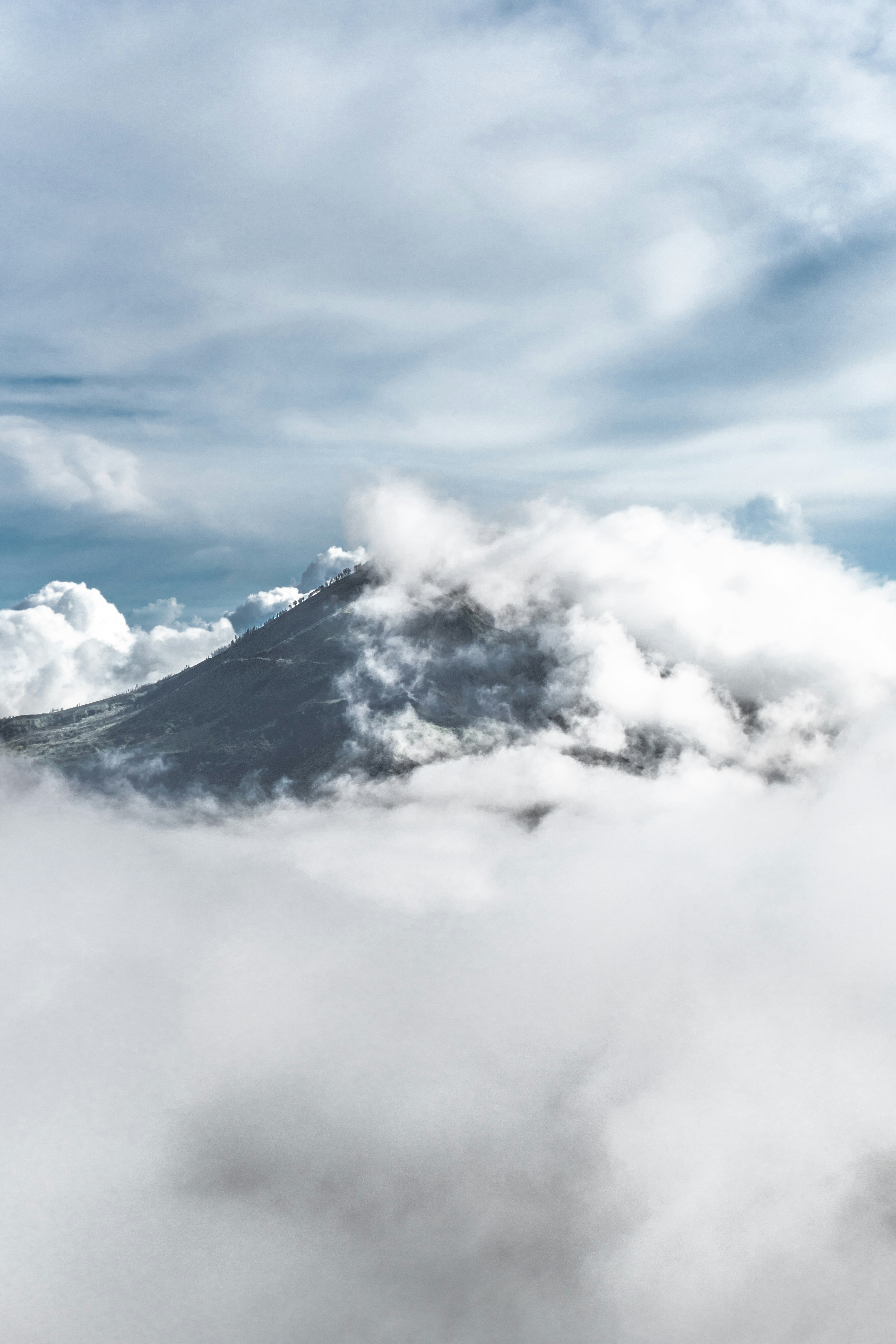 white clouds over black mountain